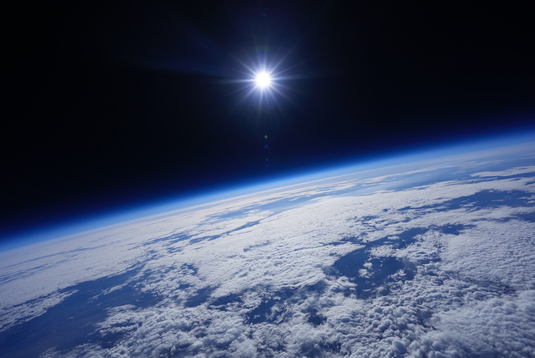 The Earth from space, with the sun glairing